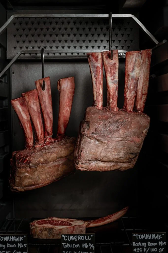 The dry-aging chamber at Gooseberry French Restaurant in Bingin, Uluwatu, with Wagyu tomahawk ribeye racks aging on hooks