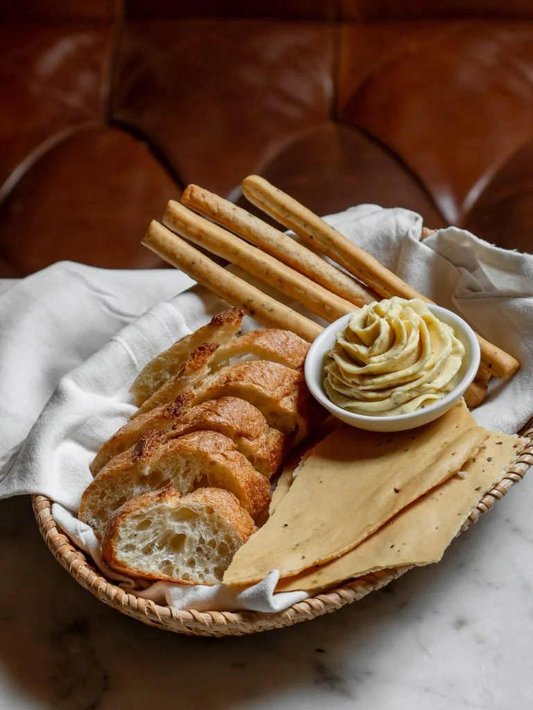 Bread basket at dinner with baguette, breadsticks and whipped butter, baked in L’Atelier at Gooseberry, Bingin, Uluwatu