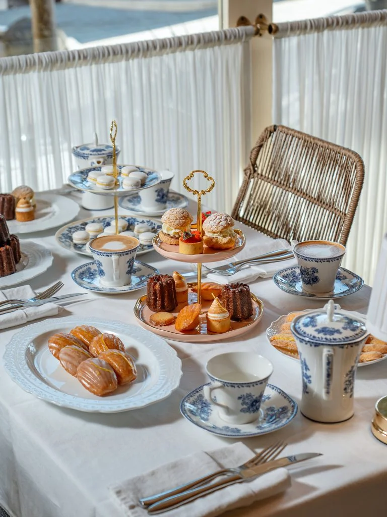 Le Goûter by Gooseberry, a French Afternoon Tea table with pâtisserie stands, madeleines and coffee on the terrace at Gooseberry, Bingin, Uluwatu